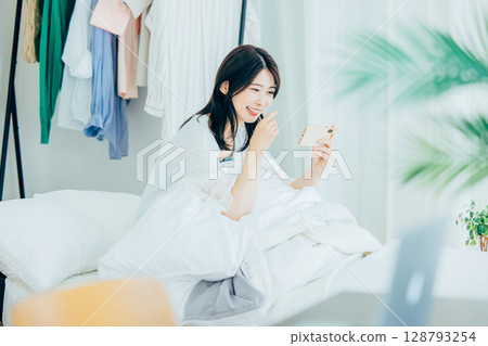 A young woman watching a video on her smartphone A young woman watching a video on her smartphone 128793254