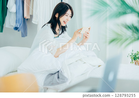 A young woman watching a video on her smartphone A young woman watching a video on her smartphone 128793255