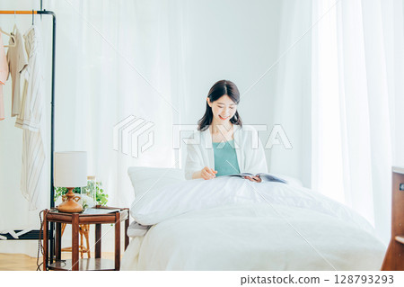 Woman reading a magazine on the bed 128793293