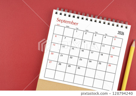 September 2026 desk calendar and pencil on red color background. 128794240