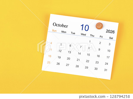 October 2026 card calendar and wooden push pin on yellow color wall. October 2026 card calendar and wooden push pin on yellow color wall. 128794258