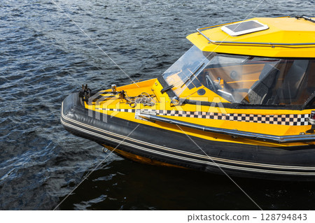 Yellow Water Taxi Docked on a Calm River Surface Close-Up Yellow Water Taxi Docked on a Calm River Surface Close-Up 128794843