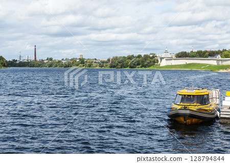 Yellow Motorboat Moored on a Scenic River with Fort in Background 128794844