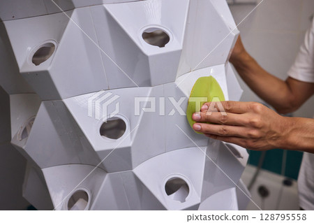 Engaging in a Cleaning Activity within a Contemporary Bathroom Environment Setting 128795558
