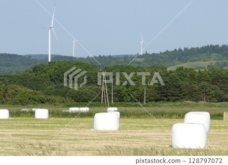Hokkaido's famous power generating windmills and hay rolls, hay rolls, roll bale wrap silos 128797072