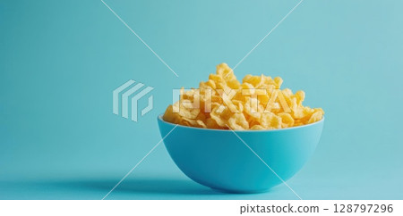 Bowl of Cornflakes on Blue Background, Ready to Eat for Breakfast Snack Time 128797296