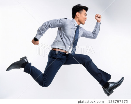 A businessman in a suit running and jumping A businessman in a suit running and jumping 128797575