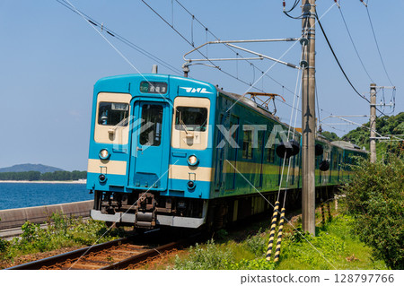 JR 103 series train in JNR colours running along the coastal Chikuhi Line 128797766