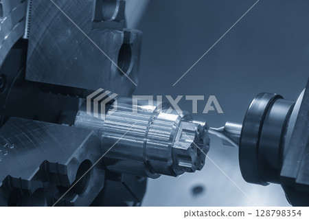 The CNC lathe machine drilling process on metal shaft parts by center drill tool in the blue tone. 128798354