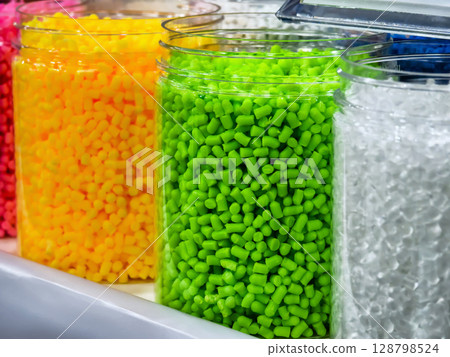 Bright colorful plastic pellets displayed in storage jars 128798524
