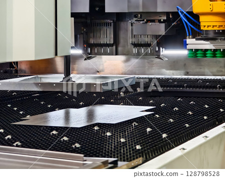 High-precision industrial laser cutting process in a modern manufacturing facility High-precision industrial laser cutting process in a modern manufacturing facility 128798528