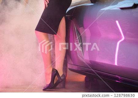 An Elegant Woman Gracefully Posing By a Luxury Car While Dressed in Chic and Stylish Attire 128798630