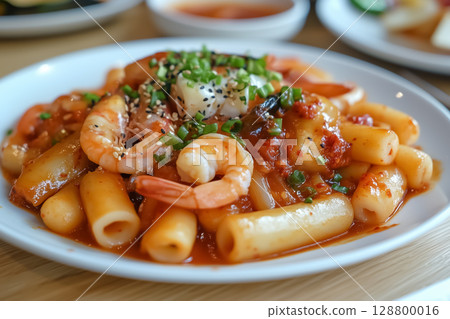 A plate of teokbokki with added seafood like shrimp and squid A plate of teokbokki with added seafood like shrimp and squid 128800016