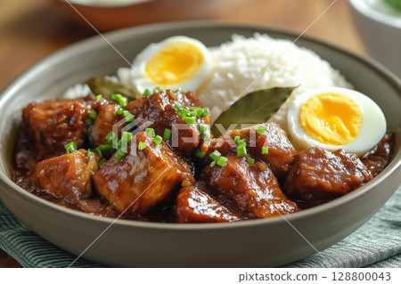Adobo served in a clay pot with tender pork belly and vinegar sauce 128800043