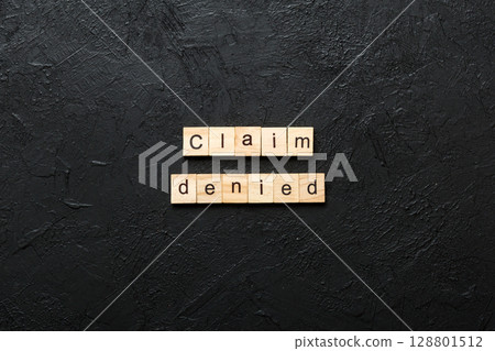claim denied word written on wood block. claim denied text on table, concept claim denied word written on wood block. claim denied text on table, concept 128801512
