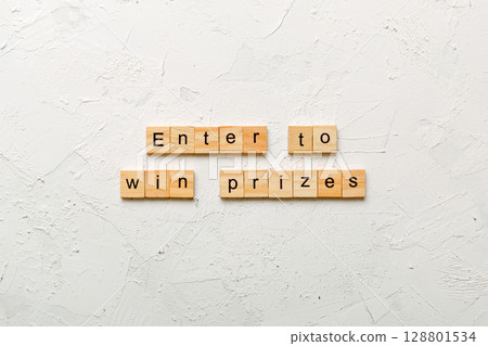 Enter to win prizes word written on wood block. Enter to win prizes text on cement table for your desing, Top view concept 128801534