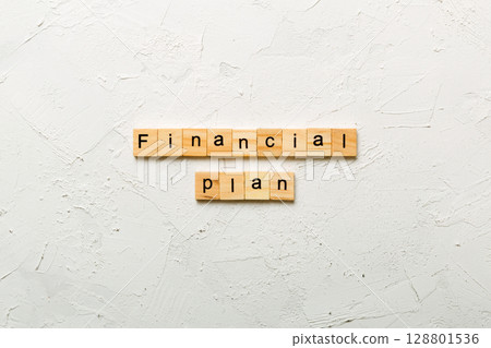 financial plan word written on wood block. financial plan text on cement table for your desing, concept financial plan word written on wood block. financial plan text on cement table for your desing, concept 128801536