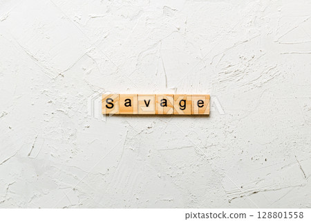 SAVAGE word written on wood block. SAVAGE text on cement table for your desing, concept 128801558