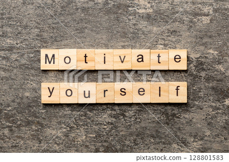 motivate yourself word written on wood block. motivate yourself text on cement table for your desing, concept motivate yourself word written on wood block. motivate yourself text on cement table for your desing, concept 128801583