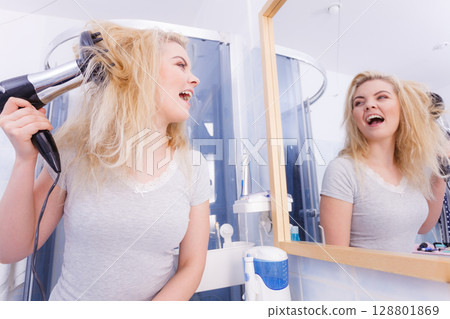 Woman doing curls with hairdryer diffuser Woman doing curls with hairdryer diffuser 128801869