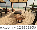 Seating area under a canopy on a sunny beach with a person enjoying the ocean view in the popular summer travel destination in Koh Rong Sanloem, Sihanoukville, Cambodia 128801959