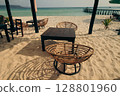 Wicker chairs and a table on sandy beach facing the turquoise ocean in Koh Rong Sanloem, Sihanoukville, Cambodia 128801960