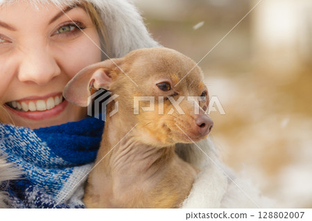 Woman playing with dog during winter Woman playing with dog during winter 128802007