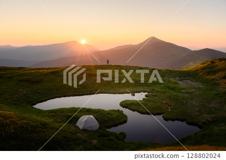 Incredible sunset on small mountain lake in summer mountains 128802024