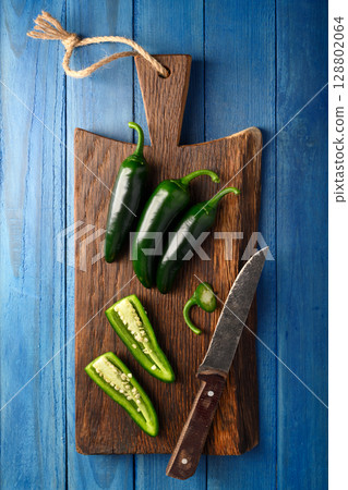 Whole and sliced green jalapeno hot peppers 128802064