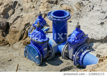 New Blue Underground Water Valve System at Construction Site with Sandy Soil and Pipe Connection 128802215