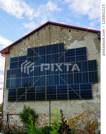 Solar Panels on Rustic Wall, Sustainable Energy Meets Vintage Architecture in Rural Setting Solar Panels on Rustic Wall, Sustainable Energy Meets Vintage Architecture in Rural Setting 128802223