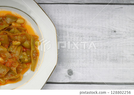 Homemade stewed green beans, tomatoes, garlic with olive oil. Zeytinyagli fasulye traditional food. Turkish cuisine. Homemade stewed green beans, tomatoes, garlic with olive oil. Zeytinyagli fasulye traditional food. Turkish cuisine. 128802256