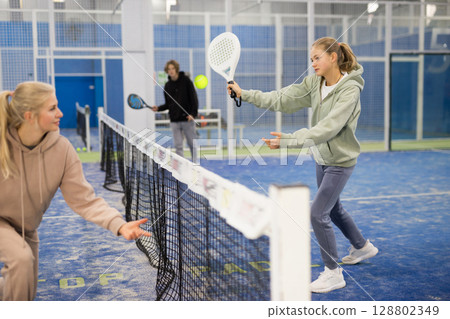 Girl tennis player plays padel with a European woman Girl tennis player plays padel with a European woman 128802349