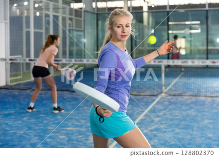 European woman playing padel 128802370