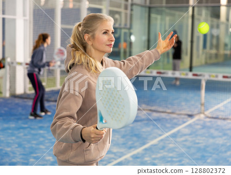 Woman playing padel in court 128802372