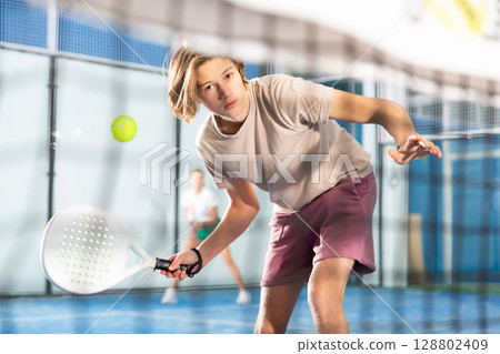 Portrait of a guy tennis player playing padel 128802409
