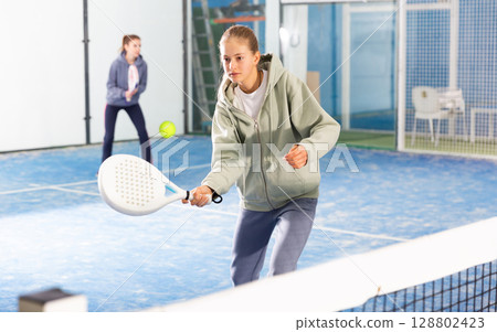 Young girl with racquet playing padel Young girl with racquet playing padel 128802423