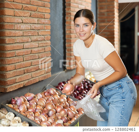 Young female customer made beeline for fresh produce section, pick up onion for morning salad 128802461