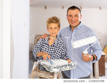 Boy with father holding renovating home tools Boy with father holding renovating home tools 128802496