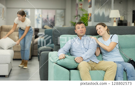Spouses in store inspects upholstered furniture. Spouses in store inspects upholstered furniture. 128802573