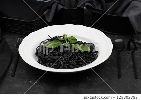 Spaghetti pasta with black ink squids on wooden background. 128802782