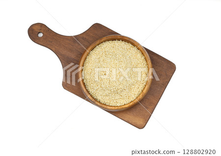 Top view closeup of freshly harvested white sesame in wooden bowl isolated on white background with clipping path. 128802920