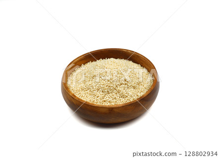 Top view closeup of freshly harvested white sesame in wooden bowl isolated on white background with clipping path. Top view closeup of freshly harvested white sesame in wooden bowl isolated on white background with clipping path. 128802934