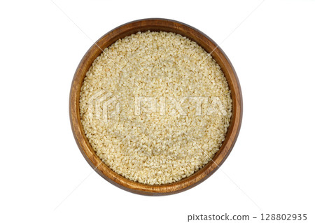 Top view closeup of freshly harvested white sesame in wooden bowl isolated on white background with clipping path. Top view closeup of freshly harvested white sesame in wooden bowl isolated on white background with clipping path. 128802935