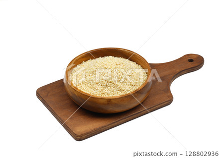 Top view closeup of freshly harvested white sesame in wooden bowl isolated on white background with clipping path. 128802936