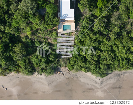 Unique coastal retreat with modern design nestled in lush greenery near sandy beach Unique coastal retreat with modern design nestled in lush greenery near sandy beach 128802972