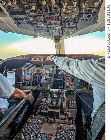 Pilots in airplane cockpit navigating aircraft in daylight over scenic horizon. High quality photo Pilots in airplane cockpit navigating aircraft in daylight over scenic horizon. High quality photo 128803138