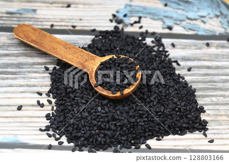 Black cumin seeds and essential oil with bowl and wooden shovel or spoon. Nigella Sativa in glass bottle. Organic herbal medicine for many diseases Black cumin seeds and essential oil with bowl and wooden shovel or spoon. Nigella Sativa in glass bottle. Organic herbal medicine for many diseases 128803166