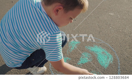 Clean planet Earth, boy child draws chalk asphalt, Kid child baby boy, Young boy making chalk Earth, educational fun outside, painting planet on street, pro-environment message, happy young creator 128803684