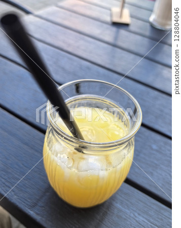 Refreshing citrus drink on a sunny day at an outdoor cafe table 128804046